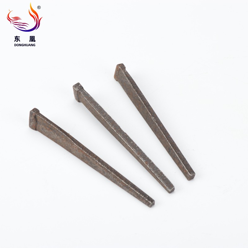 Square Galvanized Long Masonry Steel Nails Square Galvanized Long Masonry Steel Nails driven into masonry block highlighting flat head and galvanized finish
